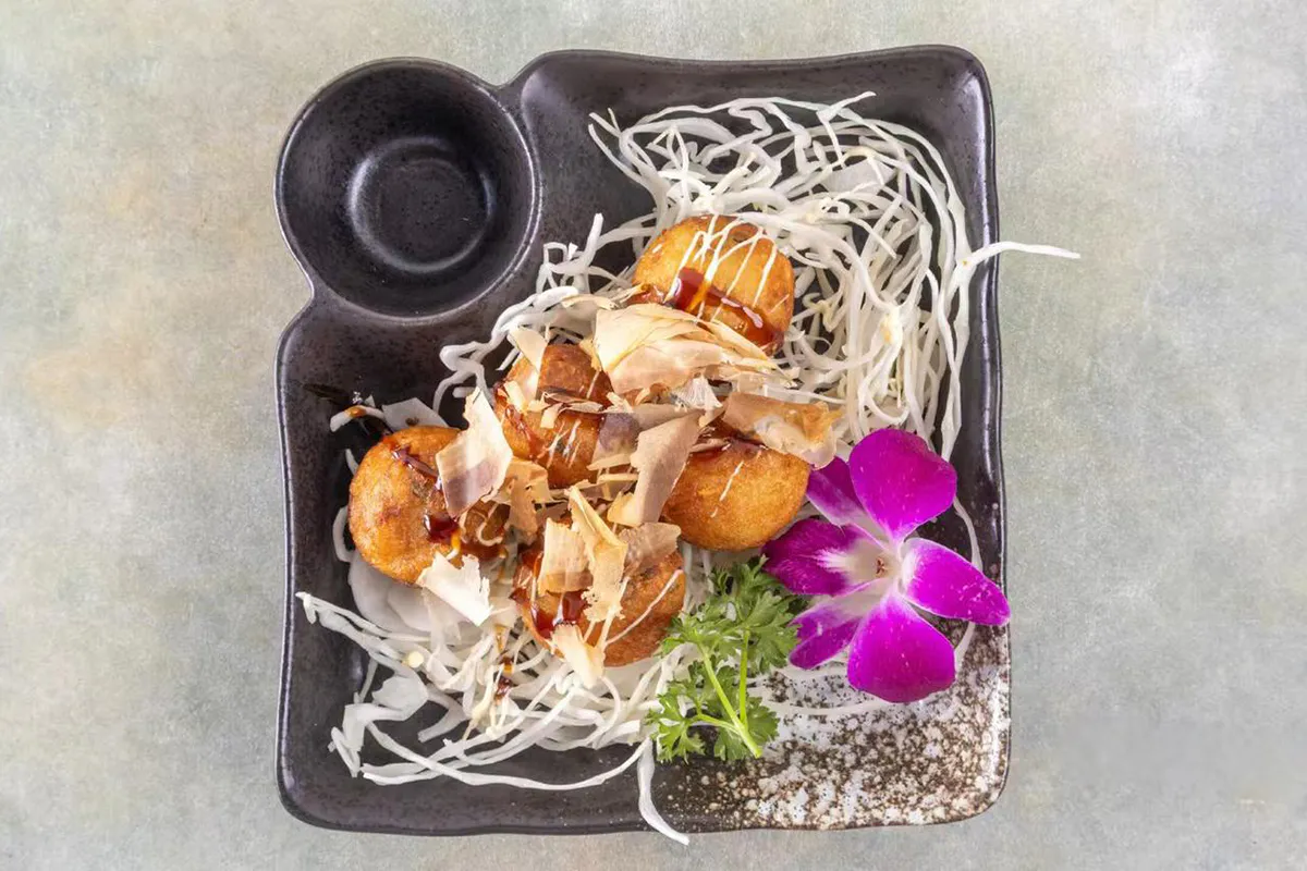 Takoyaki topped with sauce mayo and bonito flakes at Wabi Wok & Ramen, an Asian Restaurant in Milford