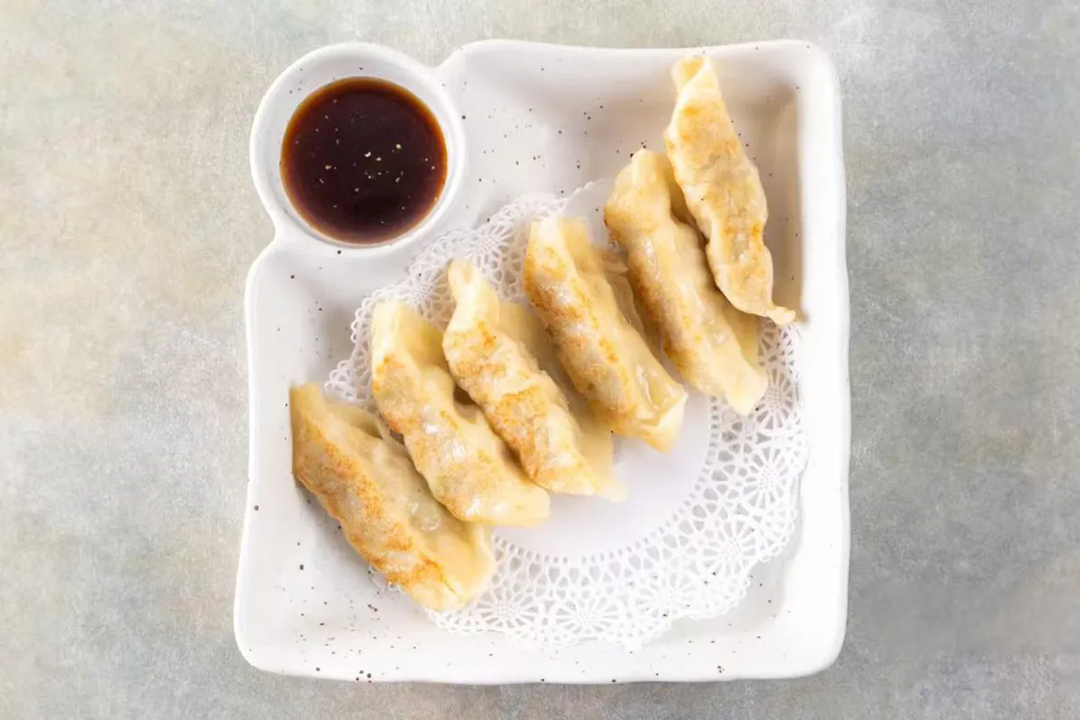 Pan fried dumplings with dipping sauce at Wabi Wok & Ramen, an Asian Restaurant in Milford