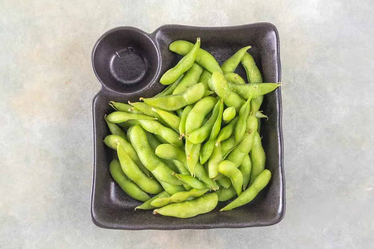 Steamed edamame served in a black dish at Wabi Wok & Ramen, an Asian Restaurant in Milford